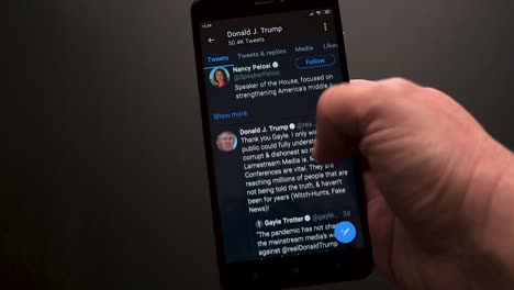 Nahaufnahme-Einer-Männlichen-Hand,-Die-Mit-Einem-Smartphone-Durch-Den-Twitter-Account-Von-Donald-Trump-Scrollt