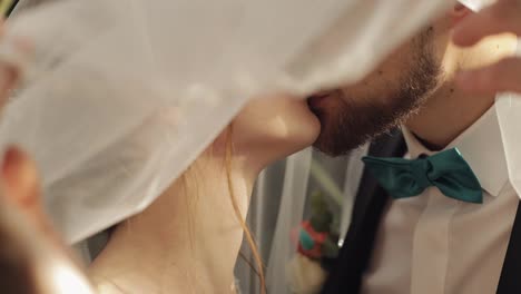 Newlyweds.-Caucasian-groom-with-bride-kissing-under-the-veil.-Wedding-couple