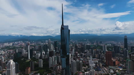 Aerial-view-orbiting-the-Merdeka-118-tower,-sunny-day-in-Kuala-Lumpur,-Malaysia