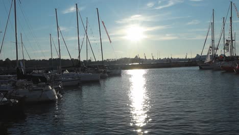 Video-of-vintage-and-small-yachts,-boats-and-ships-at-a-harbor-docked-with-flags-on-their-masts-waving-in-slow-motion-during-the-summer-time-in-4K-resolution-in-Tallinn-Estonia-Europe