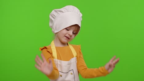 Funny-child-girl-kid-dressed-cook-chef-baker-in-apron-and-hat-dancing,-fooling-around,-making-faces