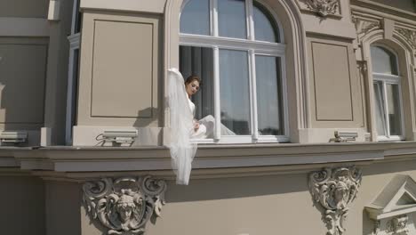 Novia-En-Vestido-Boudoir-Sentada-En-El-Alféizar-De-La-Ventana-Preparativos-De-La-Mañana-De-Boda-Mujer-En-Vestido-De-Noche,-Velo