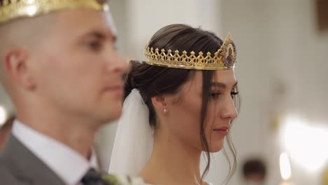 Los-Recién-Casados,-La-Novia-Y-El-Novio-Están-De-Pie-En-La-Iglesia-Con-Coronas,-Ceremonia-De-Boda