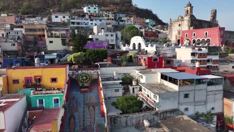 Drone-aerial-overlooking-the-Flowers-Clock-Monument,-colored-stairs-with-indigenous-portraits-and-the-San-Francisco-Former-Convent