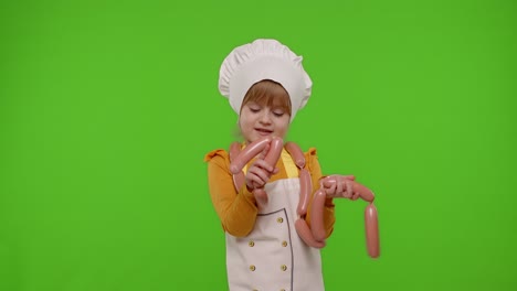 Teen-child-girl-dressed-as-cook-chef-in-apron-dancing-with-sausages,-fooling-around-on-chroma-key