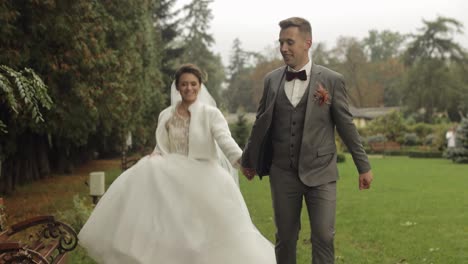 Lovely-newlyweds-caucasian-bride-groom-running-in-park,-holding-hands,-wedding-couple-family