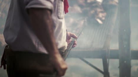 Close-up-of-chef-moving-roast-meat-on-barbecue-in-restaurant