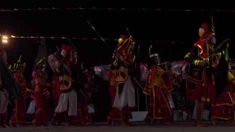 Traditional-dancing-of-a-group-with-costumes,-celebrating-the-Nias-Pro-Surf-Competition-at-night,-static-shot-with-copy-space