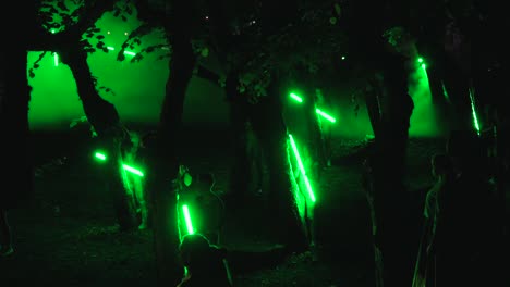 Un-Grupo-De-Bailarines-Realizando-Danzas-étnicas-En-La-Oscuridad,-Rodeados-De-árboles.