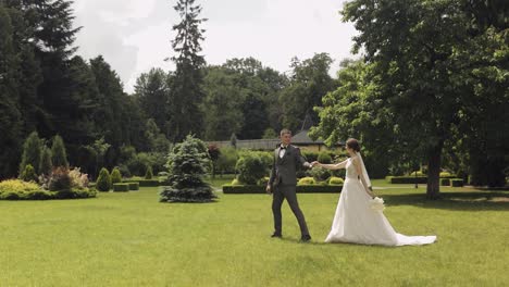 Lovely-newlyweds-caucasian-bride-groom-walking-in-park,-holding-hands,-wedding-couple-family