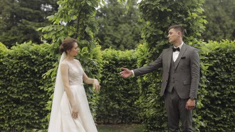 Newlyweds,-caucasian-groom-with-bride-walking,-embracing,-hugs-in-park,-wedding-couple