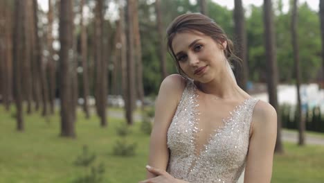 Beautiful-and-lovely-bride-in-wedding-dress-and-veil-in-the-park-waiting-for-groom.-Slow-motion