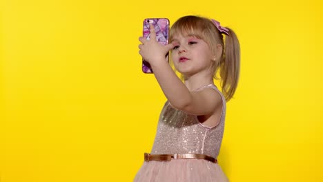 Child-girl-using-smartphone.-Portrait-of-blonde-kid-emotionally-makes-selfie-on-mobile-phone