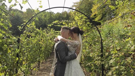 Lovely-newlyweds-caucasian-bride-embracing-groom-in-park-making-kiss,-wedding-couple-family-hugging