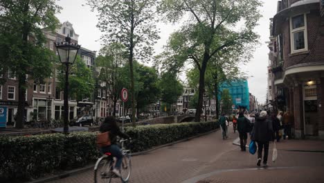 Street-Scene-With-Bicycle-Riders-In-Amsterdam,-Netherlands,-Europe