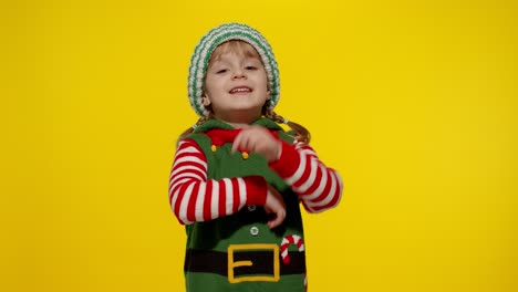 Kid-girl-in-Christmas-elf-Santa-helper-costume-dancing,-fooling-around.-New-Year-holiday-celebration