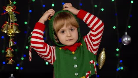 Kid-girl-in-Christmas-elf-Santa-helper-costume-dancing,-fooling-around.-New-Year-holiday-celebration