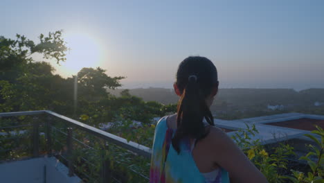 Una-Mujer-Disfruta-Del-Atardecer-En-El-Balcón-Del-Hotel-Renaissance-Bali-Uluwatu-Resort-And-Spa-En-Bali,-Indonesia