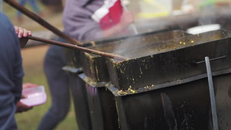 Several-Cauldrons-of-Typical-Locro-Stew-being-Stirred-in-Gastronomic-Argentine-Festivities,-Slow-Motion