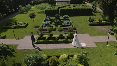 Newlyweds-bride-and-groom-with-bouquet-in-park,-wedding-couple-first-meeting,-aerial-drone-view