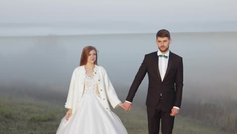 Newlyweds.-Caucasian-groom-with-bride-on-the-morning-field.-Fog.-Wedding-couple