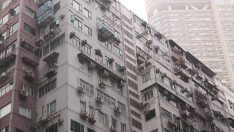 Residential-Area-In-Hong-Kong,-Apartment-Building-Next-To-Tower,-Tilt-Up-View