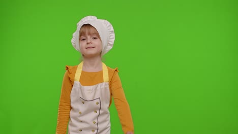 Child-girl-dressed-like-chef-cook-pointing-at-right-on-blank-space-place-for-your-advertisement-logo