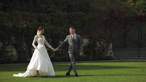 Lovely-newlyweds-caucasian-bride-groom-walking-in-park,-holding-hands,-wedding-couple-family