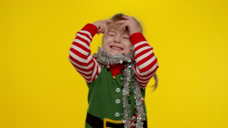 Kid-girl-in-Christmas-elf-Santa-helper-costume-dancing,-fooling-around.-New-Year-holiday-celebration