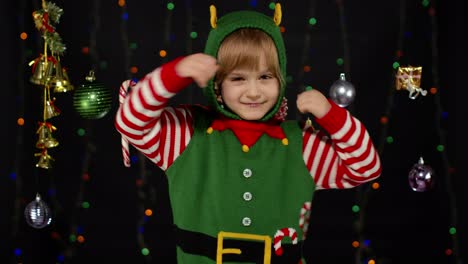 Kid-girl-in-Christmas-elf-Santa-helper-costume-dancing,-fooling-around.-New-Year-holiday-celebration