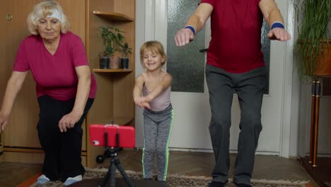 Old-grandmother-grandfather-with-child-girl-kid-doing-workout-exercises,-training,-fitness-at-home