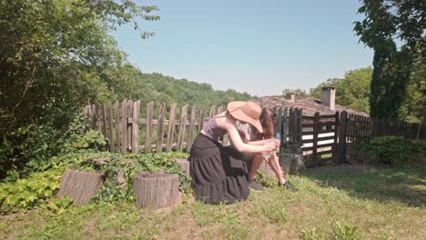 Student-travel-couple-rest-on-rustic-tree-stumps,-romantic-Bulgarian-village