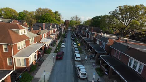 Residential-street-in-Harrisburg,-Pennsylvania,-lined-with-brick-houses-and-parked-cars