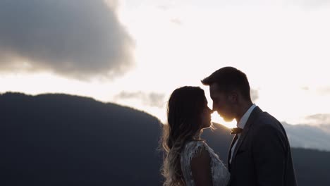 Lovely-young-newlyweds-bride-groom-hugging-on-mountain-slope,-holding-hands,-wedding-couple-family