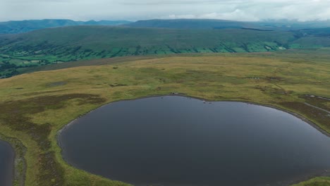 Aerial-pull-back-shot-capturing-Whernside-tarns-during-daytime-in-Northern-England