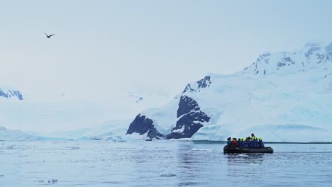 Antarctica-Boat-Trip-and-Scenery-of-Mountains-and-Ice-on-Antarctic-Peninsula,-Tourists-People-Travelling-in-Beautiful-Dramatic-Winter-Scenery-on-Zodiac-Boat-Tour,-a-Unique-Adventure-Travel-Experience