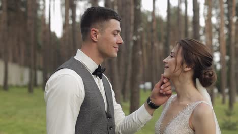 Newlyweds,-caucasian-groom-with-bride-walking,-embracing,-hugs-in-park,-wedding-couple