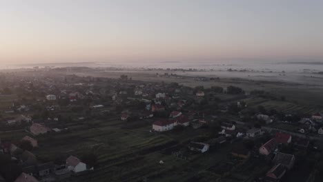 Aerial-drone-view-over-old-village-at-sunrise.-Thick-fog-covered-all-the-fields