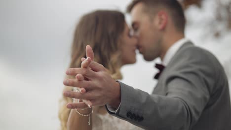 Lovely-caucasian-wedding-newlyweds-family-bride-groom-holding-hands,-making-a-kiss-on-mountain-slope