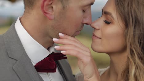 Lovely-young-newlyweds-bride-and-groom-embracing,-hugging-on-mountain-slope,-wedding-couple-in-love