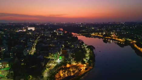 Beautiful-aerial-drone-shot-of-Nashik-city-showing-densely-packed-building,-dramatic-sky-and-river,-Maharashtra-India-4K