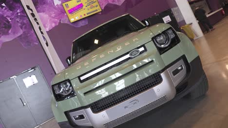 360-roll-shot-of-a-green-Land-Rover-Defender-on-display-at-a-show