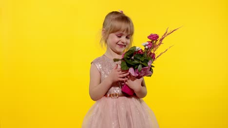 Little-child-girl-with-fashion-makeup-standing-with-bouquet-of-flowers-isolated-on-yellow-background