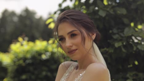 Beautiful-and-lovely-bride-in-wedding-dress-and-veil-in-the-park-waiting-for-groom.-Slow-motion