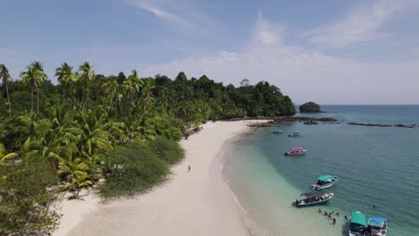 Aerial-along-coastline-with-sand-beach-and-boats,-Island-Rancheria,-Panama