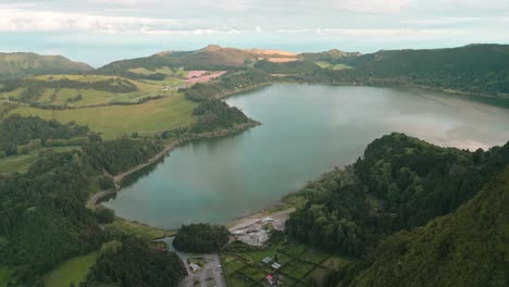 Furnas-crater-lake-and-green-rural-landscape-at-Azores,-forward-aerial