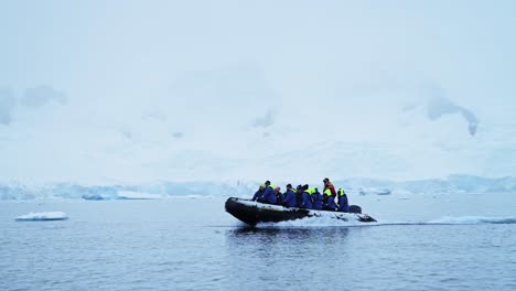 Antarctica-Boat-Trip-and-Scenery-of-Mountains-and-Ice-on-Antarctic-Peninsula,-Tourists-People-Travelling-in-Beautiful-Dramatic-Winter-Scenery-on-Zodiac-Boat-Tour,-a-Unique-Adventure-Travel-Experience