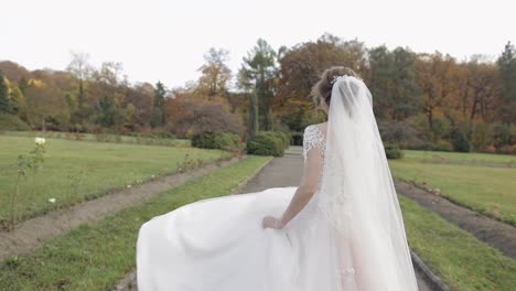 Schöne-Und-Reizende-Braut-Im-Hochzeitskleid,-Die-Im-Park-Läuft.-Zeitlupe