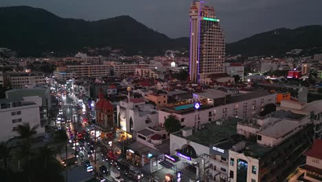 Drone-view-capturing-The-Royal-Paradise-Hotel-with-beautiful-cityscape-at-nighttime-in-Phuket,-Thailand