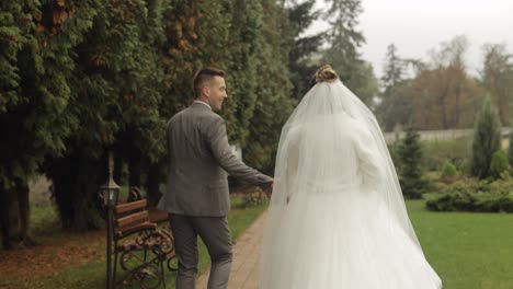 Hermosos-Recién-Casados,-Novia-Caucásica,-Novio-Corriendo-En-El-Parque,-Tomados-De-La-Mano,-Pareja-De-Novios,-Familia